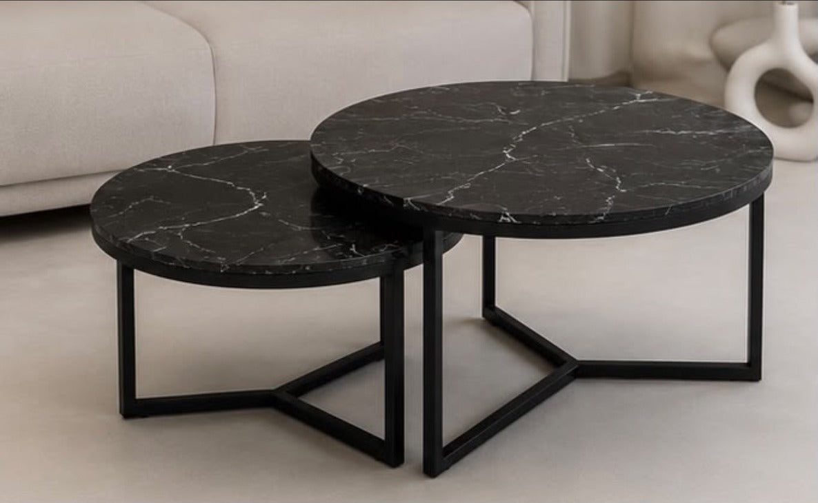 Oda nesting tables in Nero beside a sofa